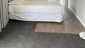 A bedroom with a bed, curtains, a television, and a window. - Dash motel (Papakura)