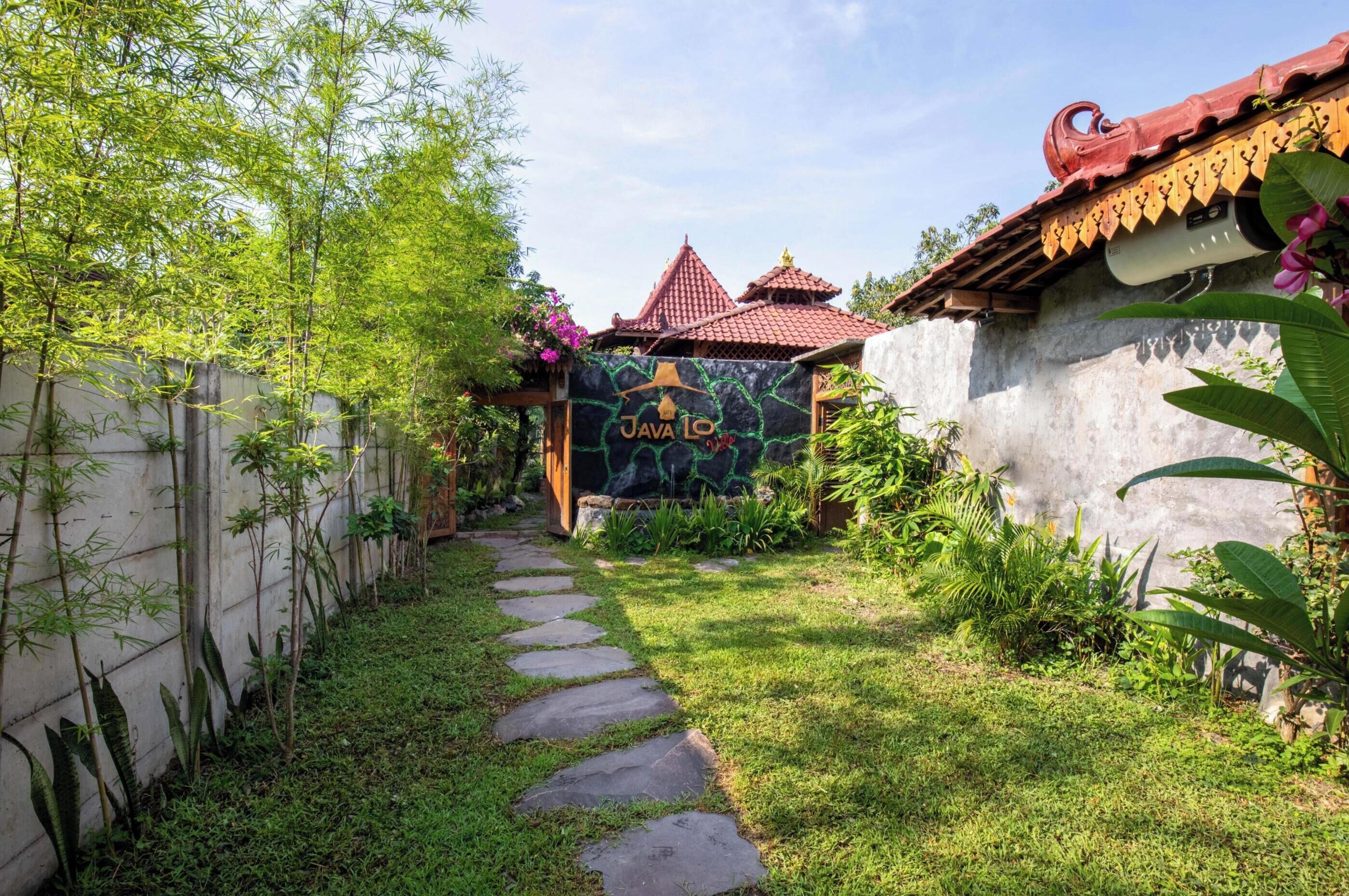 A garden pathway leading to a building with a traditional roof and a sign reading "JAVA LO".
