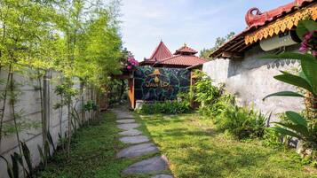A garden pathway leading to a building with a traditional roof and a sign reading "JAVA LO".