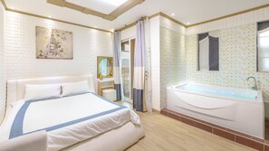 Une chambre d’hôtel avec un grand lit, une baignoire, un miroir et une vue sur l’extérieur.