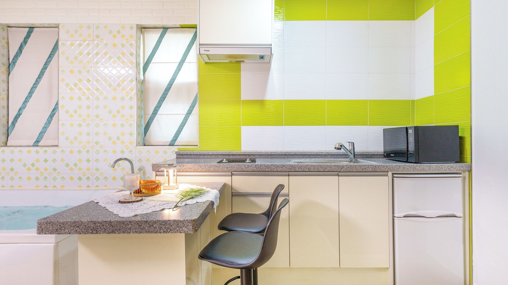 A kitchen with a granite countertop, a sink, a microwave, and a chair.