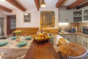 A dining area with a wooden table set for four, a fruit bowl, and a wicker basket. - The Bird of Happiness-Heaven for dogs, Nemesbük, Hungary (Nemesbük)