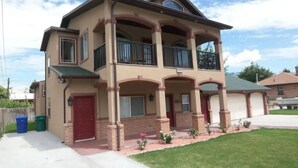 A two-story house with a balcony, a garage, and a well-maintained lawn.