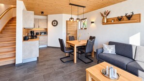 A modern kitchen with a dining area, a sofa, and a coffee table. - Mountain View - Charming townhouse for 4 people with an infrared sauna (Winterberg)