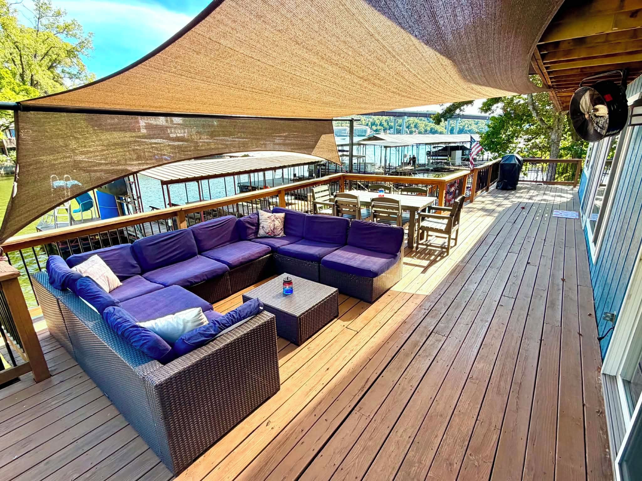 Une terrasse extérieure avec un canapé modulable, une petite table et un barbecue.