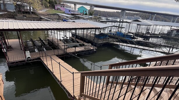 Un port de plaisance doté de plusieurs quais et d’un grand nombre de bateaux, de passerelles en bois et offrant une vue dégagée sur l’eau.