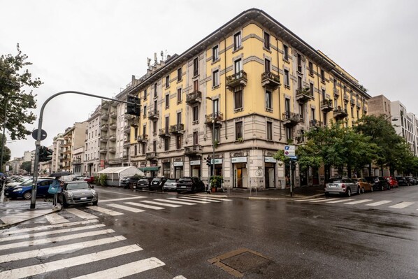Un immeuble à plusieurs étages, de style architectural classique, doté de balcons et d’une entrée située à l’angle.