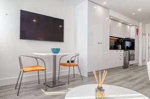 Cozy living space with a dining area, flat-screen TV, and modern kitchen.