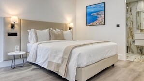 A modern bedroom with a large bed, two bedside lamps, a small table with a glass of water, and a cityscape painting on the wall. - BSE15 Apartments 4L, a Home in Madeira (Funchal)