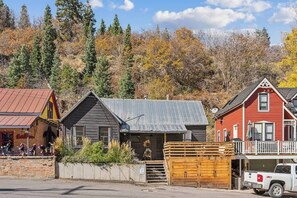 Un bâtiment de style rustique, doté d’un toit en métal, d’un porche en bois et d’un garage.