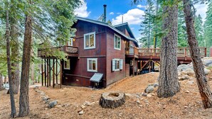 Une cabane avec une façade en bois, de nombreuses fenêtres et une terrasse.