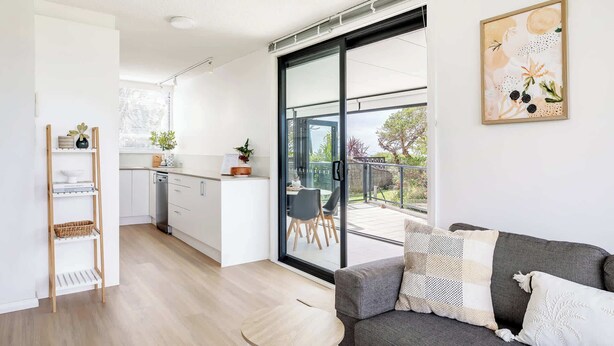 Un apartament modern amb cuina, zona de menjador i un balcó amb vistes.
