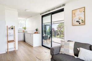 Ein modernes Apartment mit Küche, Essbereich und einem Balkon mit Blick.
