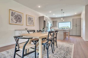 Une cuisine moderne avec un coin repas, comprenant une table en bois, des chaises et un tapis.