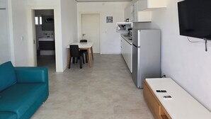 Eine moderne Wohnung mit Küchenzeile, Essbereich und Wohnraum.