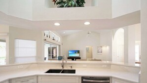 A modern kitchen with white cabinetry, a built-in dishwasher, and a large window. - Stunning 3/2 pool home in the heart of Punta Gorda - Pelican Poolside (Punta Gorda)
