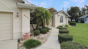 A single-story house with a garage, a front porch with a palm tree, and a well-maintained lawn. - Stunning 3/2 pool home in the heart of Punta Gorda - Pelican Poolside (Punta Gorda)