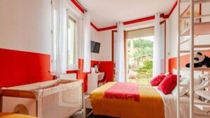 A hotel room with a bed, a desk, and a window.