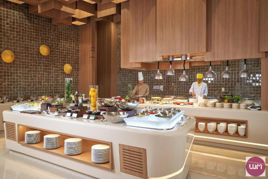 Un dispositiu de buffet modern, amb nombroses estacions de servei, una gran varietat d'aliments i un disseny net i contemporani.