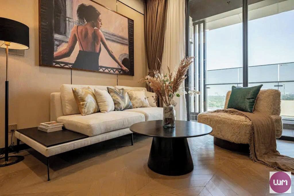 A modern living room with a sofa, a coffee table, and a chair with a view.
