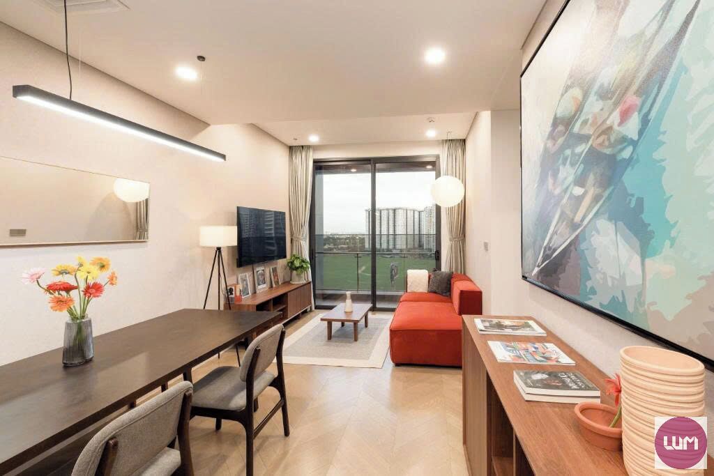 A modern hotel room with a dining area, a sofa, a TV, and a large window with a view.