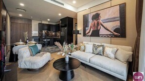 A modern living room with a sofa, a coffee table, and a painting on the wall.