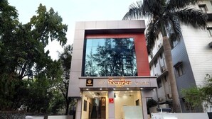 A hotel entrance with a modern design, featuring a glass facade and a checkered floor pattern. - Vishnupriya Grand (Kolhapur)