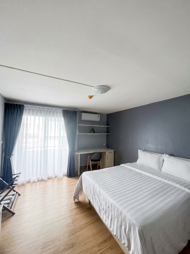Una camera d'albergo con un letto, una scrivania e una sedia.