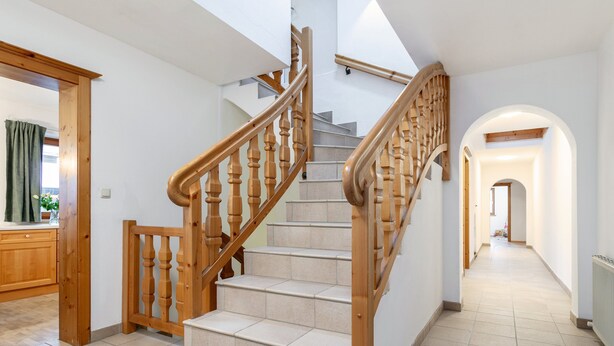 A staircase with wooden railings leading to an upper floor. - Spacious apartment in the center, garden & sauna (Kirchberg in Tirol)