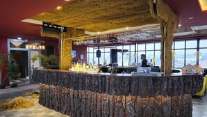 A bar area with a central island, patterned floor tiles, and a ceiling with an air conditioning unit. - HSR Hotels & Resorts (Dehradun)