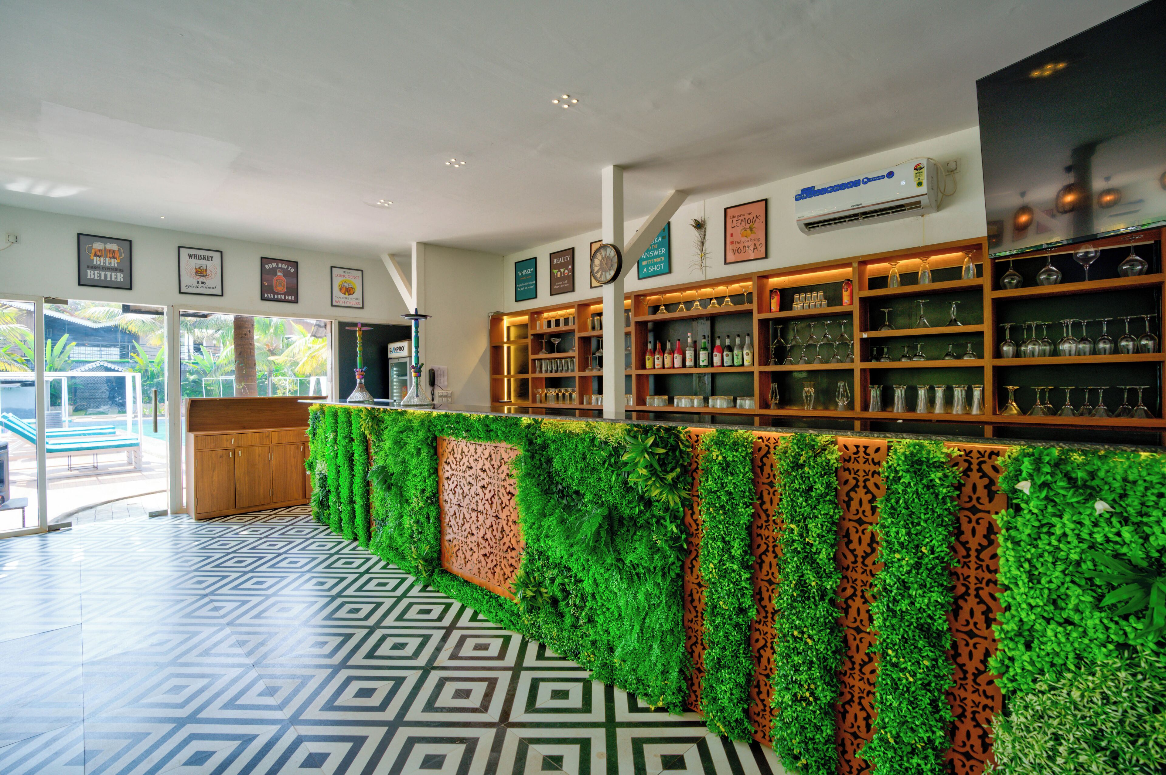 Un'area bar con una parete verde e piastrelle decorative.