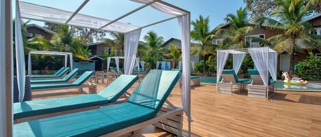 A poolside area with sun loungers and a canopy structure.