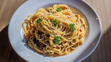 A plate of spaghetti with a garnish of parsley, served on a white plate.