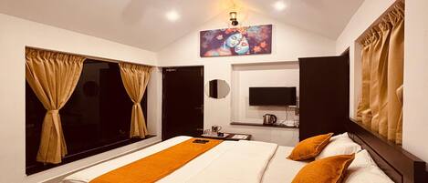A modern bedroom with a large bed, a ceiling fan, a flat-screen TV, and a painting above the bed.