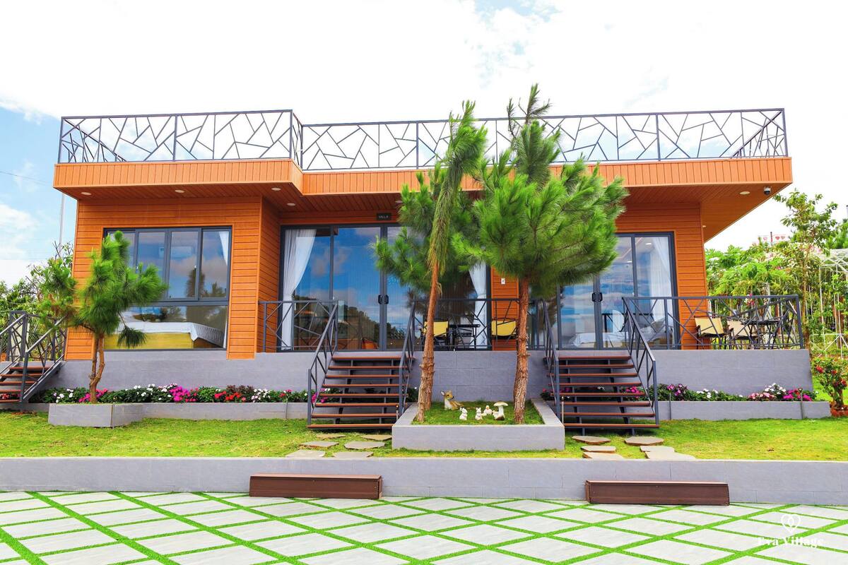 A modern building with a wooden facade, large windows, and a geometric metal balcony.