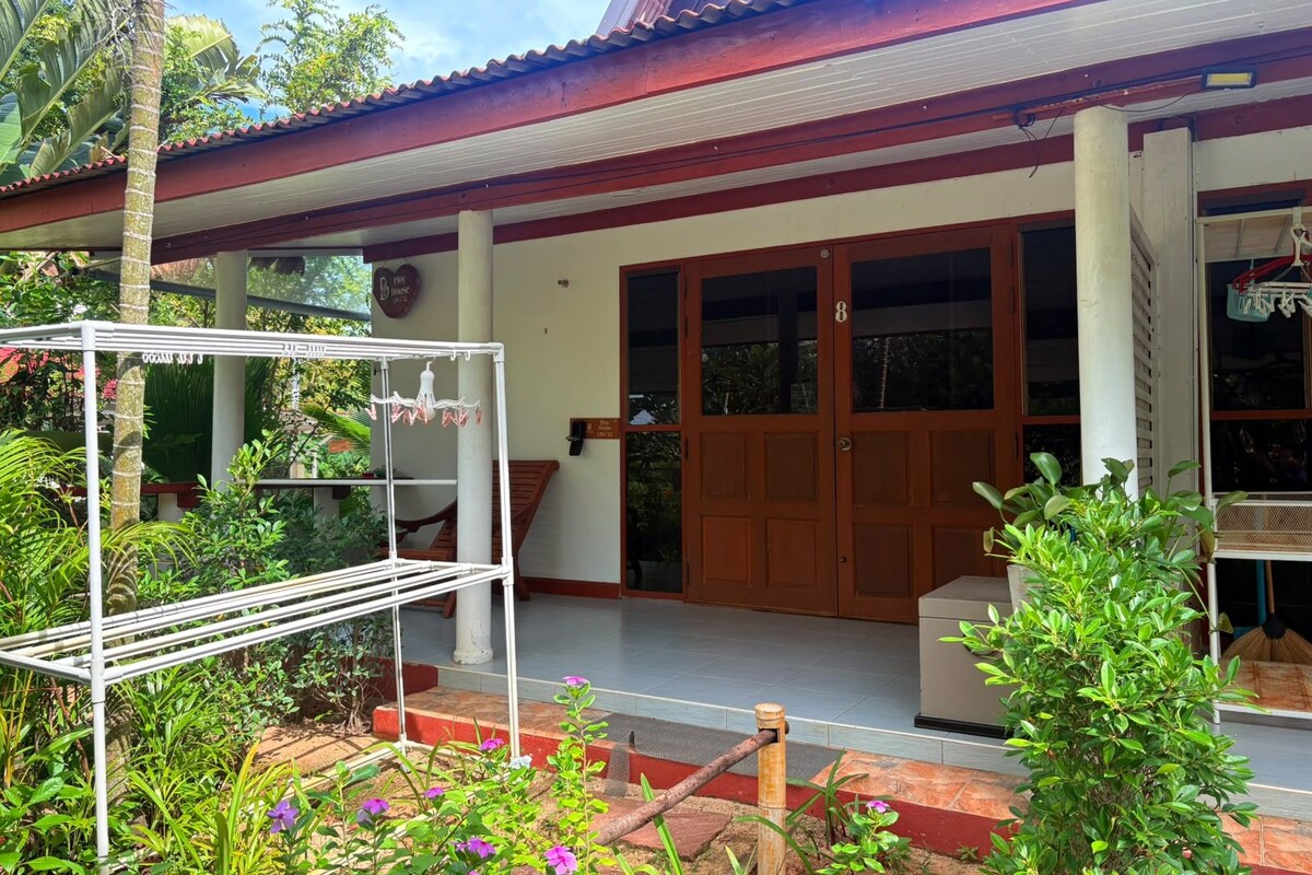 A house with a porch, a wooden door, and a garden.