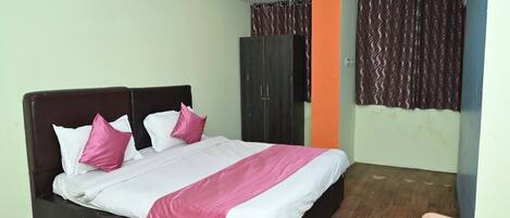 Una habitación de hotel con cama, armario y una silla.