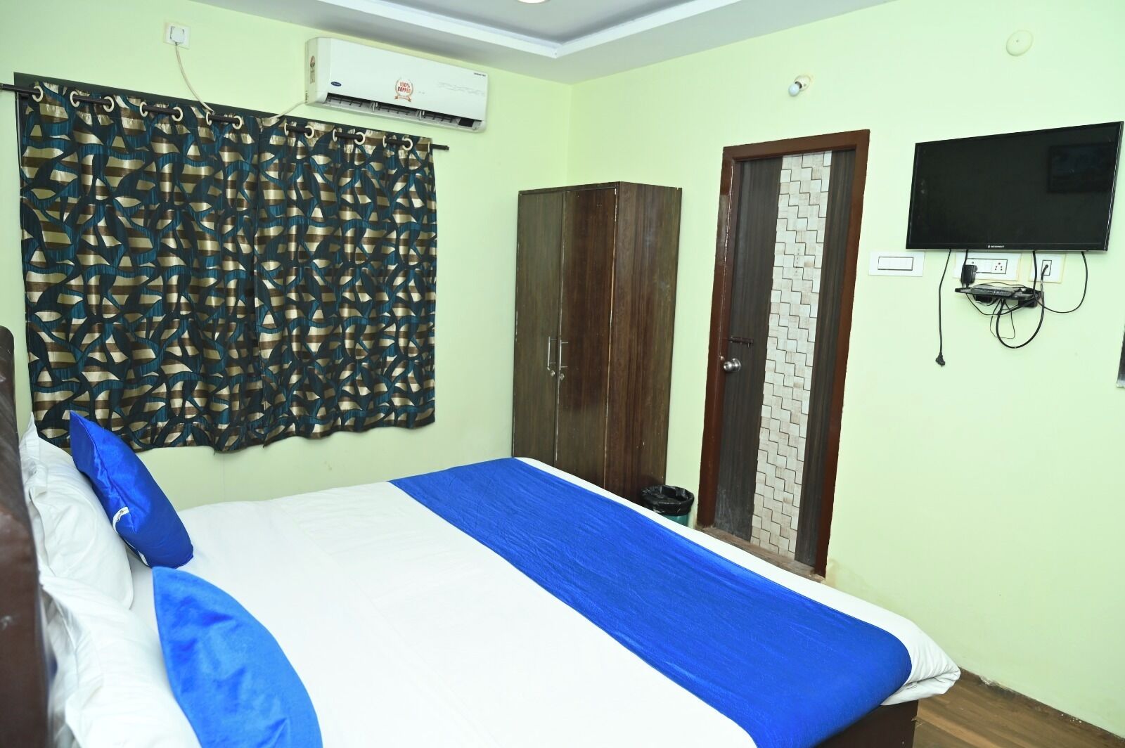 Un dormitorio con cama, armario, televisor y aire acondicionado.