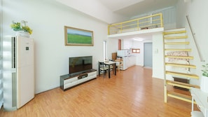 A modern apartment with a living room, kitchen, and a loft bedroom.
