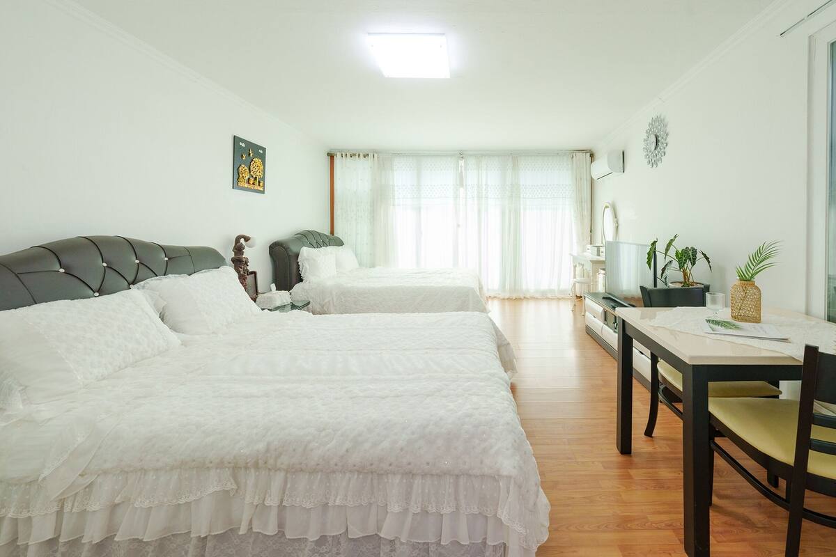 Un dormitorio con dos camas, un escritorio y una silla.