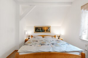 Une chambre à coucher avec un lit en bois, un tableau au mur et deux lampes de chevet.