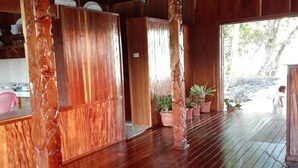 Una habitación amplia con piso de madera, techo alto y vistas al exterior.