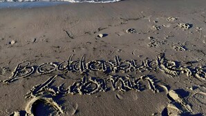 A beach with footprints and the words 'Boddenbuden, Lubbock' written in the sand. - Apartment 'Boddenbude Lubmin' with Wi-Fi (Lubmin)