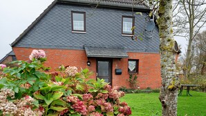 A brick house with a grey roof, a black door, and a window. - Holiday Apartment Norderwurth (Büsumer Deichhausen)