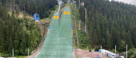 Eine Skipiste mit Sessellift, umgeben von dichtem Wald.