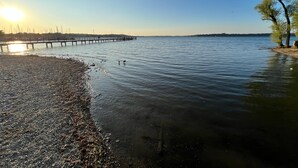 A calm lake with a pier extending into the water, surrounded by trees and a clear sky. - Vacation apartment Wolke 7 (Rottau)
