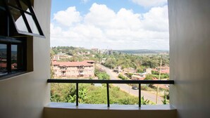 A balcony with a view of a residential area, including houses and a road. - Turbine Ngong Hotel (Ngong)