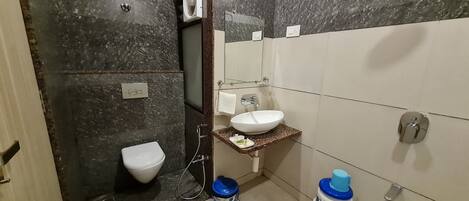 A bathroom with a toilet, sink, and shower.
