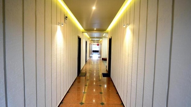 A long, narrow hallway with a shiny, reflective floor and white walls. - HOTEL SHIV SHAKTI (Goharganj)
