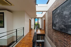 A modern interior with a skylight, wooden flooring, a blackboard with equations, and a glass railing. - Villa Pakuk by Alfred in Bali (Canggu)